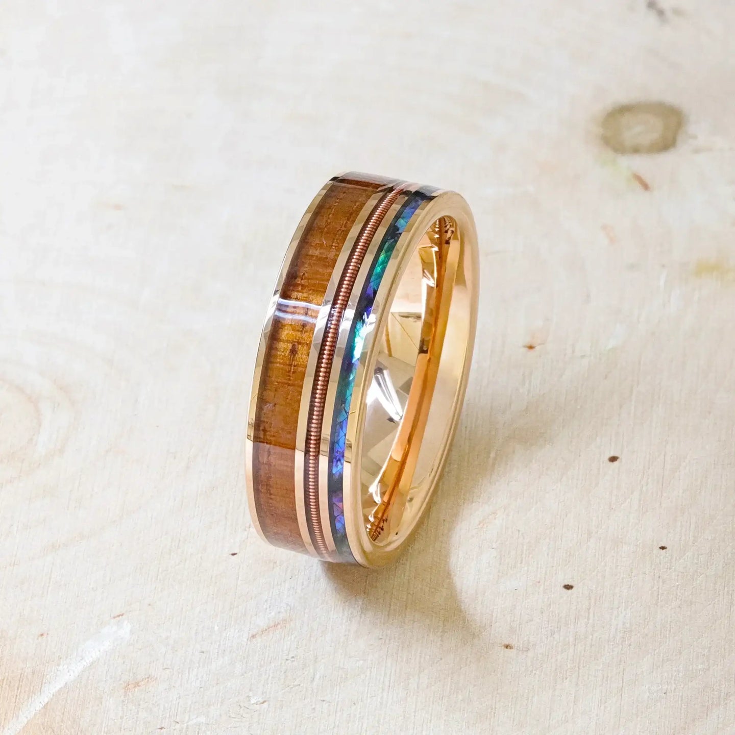 Close lifestyle image of the MOANA ring showing polished interior and detailed koa wood and abalone inlays
