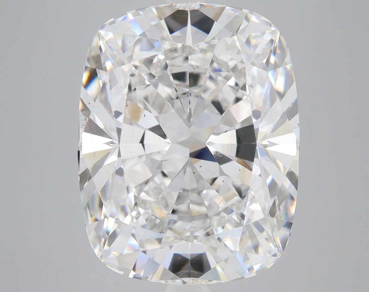 Cushion-cut lab-grown diamond with brilliant faceting and light refraction on gray background.