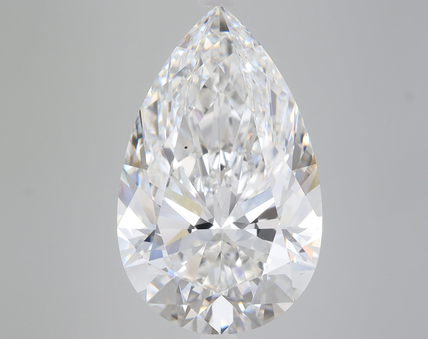 Pear-shaped lab-grown diamond with faceted surface and clear transparency on gray background.