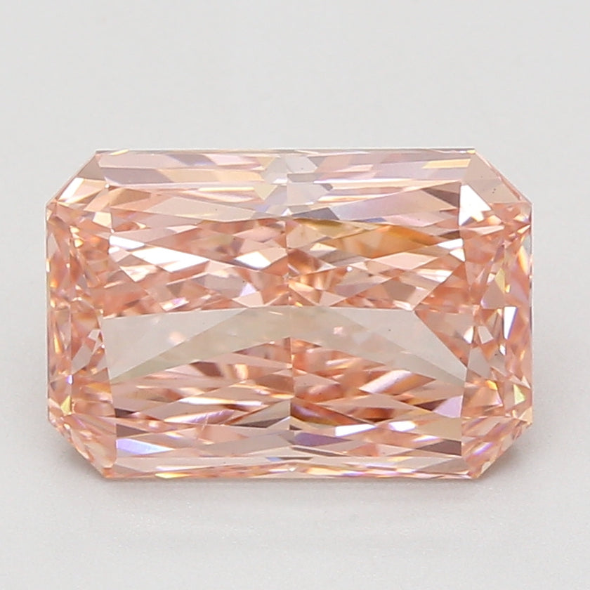 Radiant cut lab-grown diamond with peachy-pink hue and faceted surface displaying light refraction.