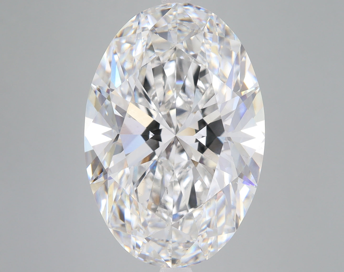 Clear oval-cut lab-grown diamond with faceted surface and light reflections on neutral background.