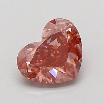 Heart-shaped lab-grown diamond with faceted surface and reddish-pink tone on white background.