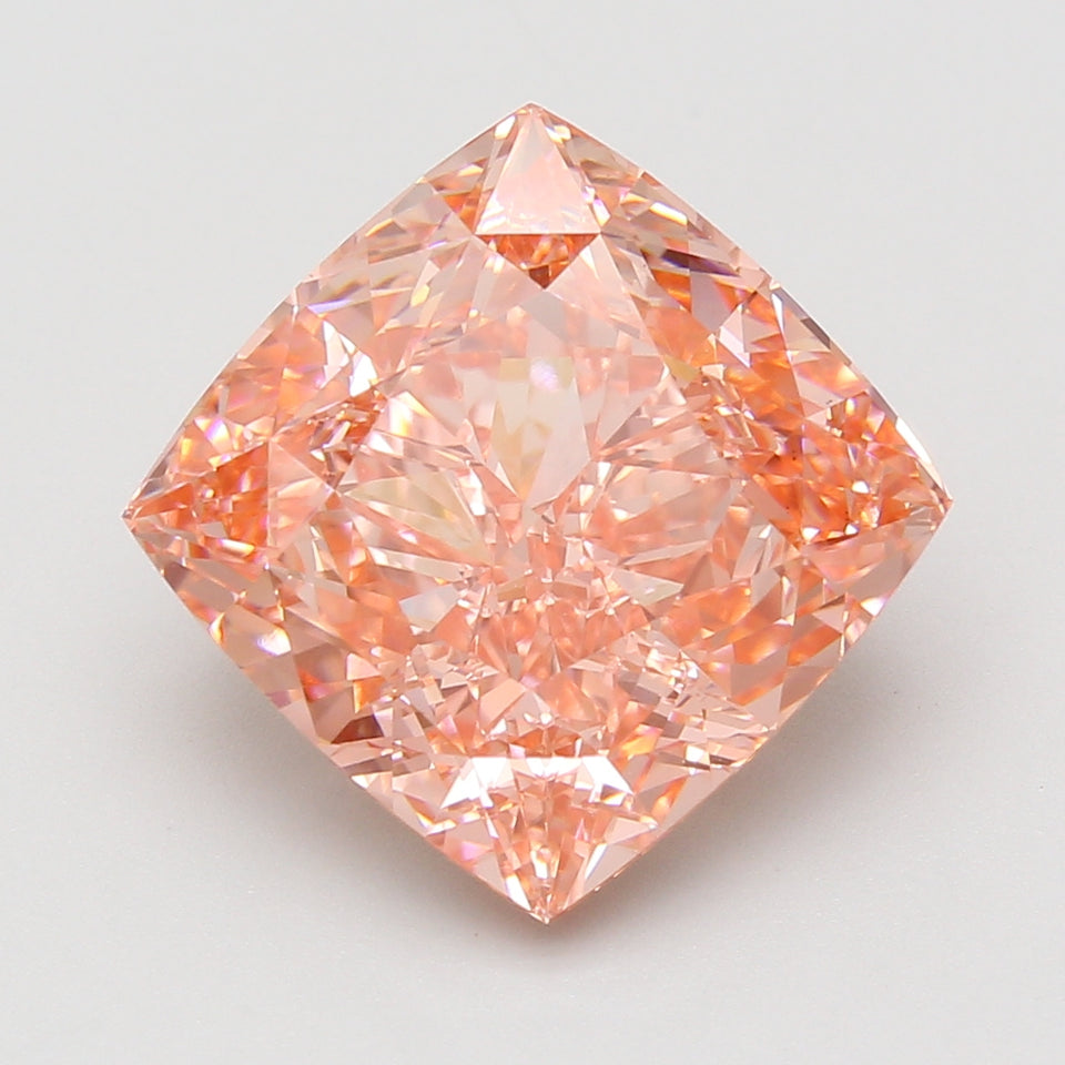 Cushion-cut lab-grown diamond with peachy-pink hue and faceted reflections on white background.