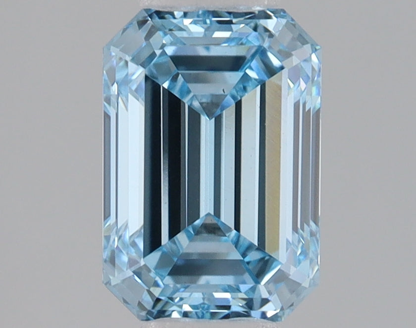 Light blue rectangular emerald cut lab grown diamond with faceted edges and reflective surfaces on neutral background.