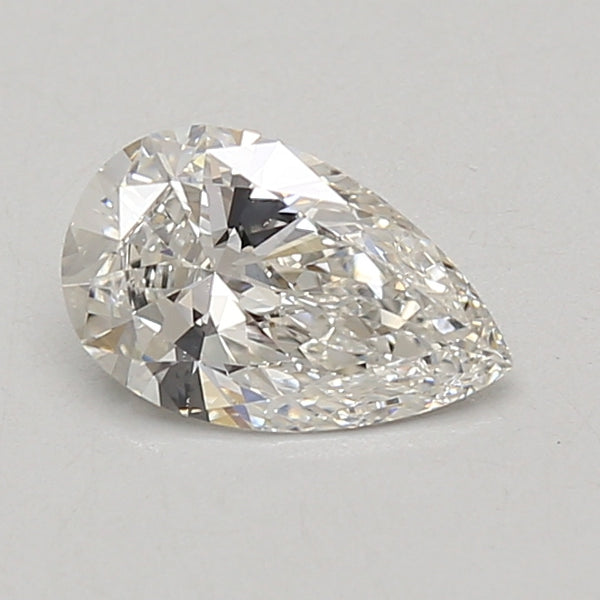 Pear-shaped lab-grown diamond with faceted surface and light reflections on neutral background.