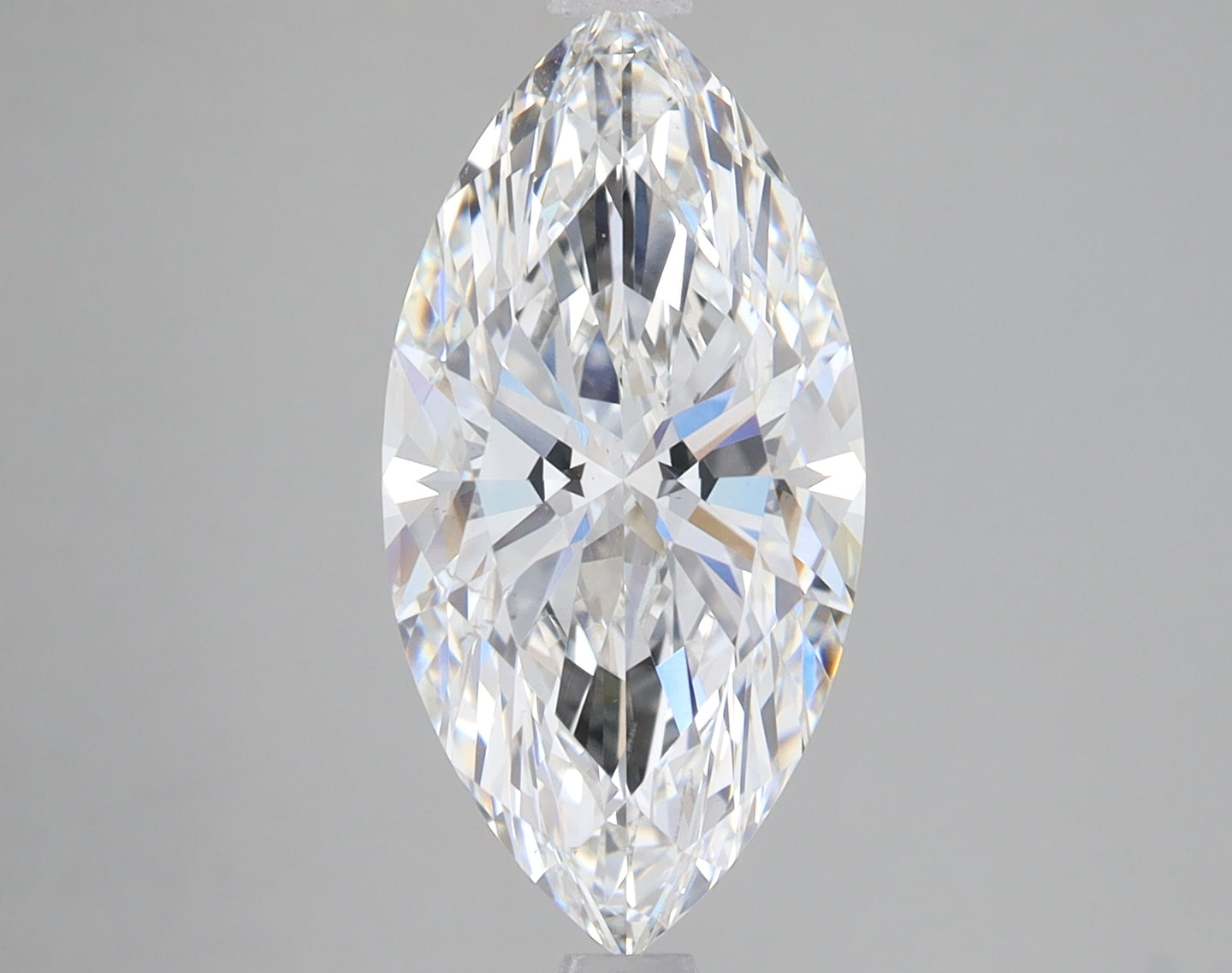 Colorless marquise-cut lab-grown diamond with faceted surface and light refraction visible against gray background.