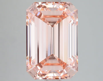 Emerald-cut lab-grown diamond with pale pink hue, displaying faceted surfaces and light reflection throughout the stone.