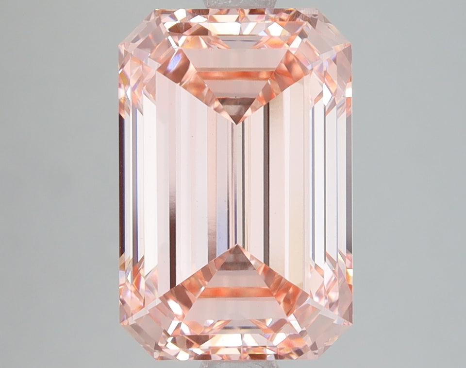 Emerald-cut lab-grown diamond with pale pink hue, displaying faceted surfaces and light reflection throughout the stone.