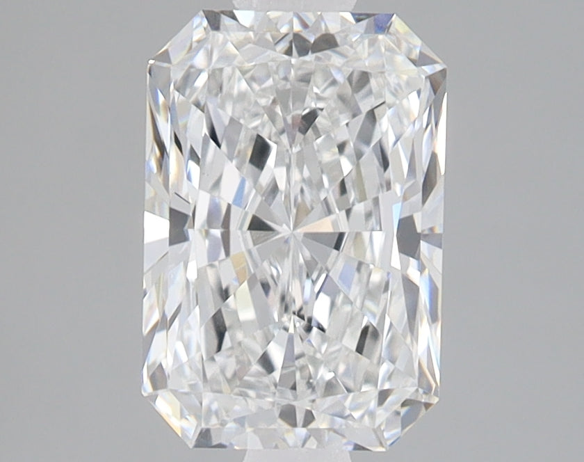 Radiant cut loose diamond with faceted surfaces reflecting light, displayed against neutral gray background.