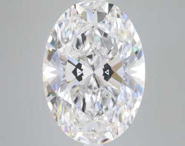 Clear oval-cut diamond with faceted surface and rainbow light refraction on gray background.