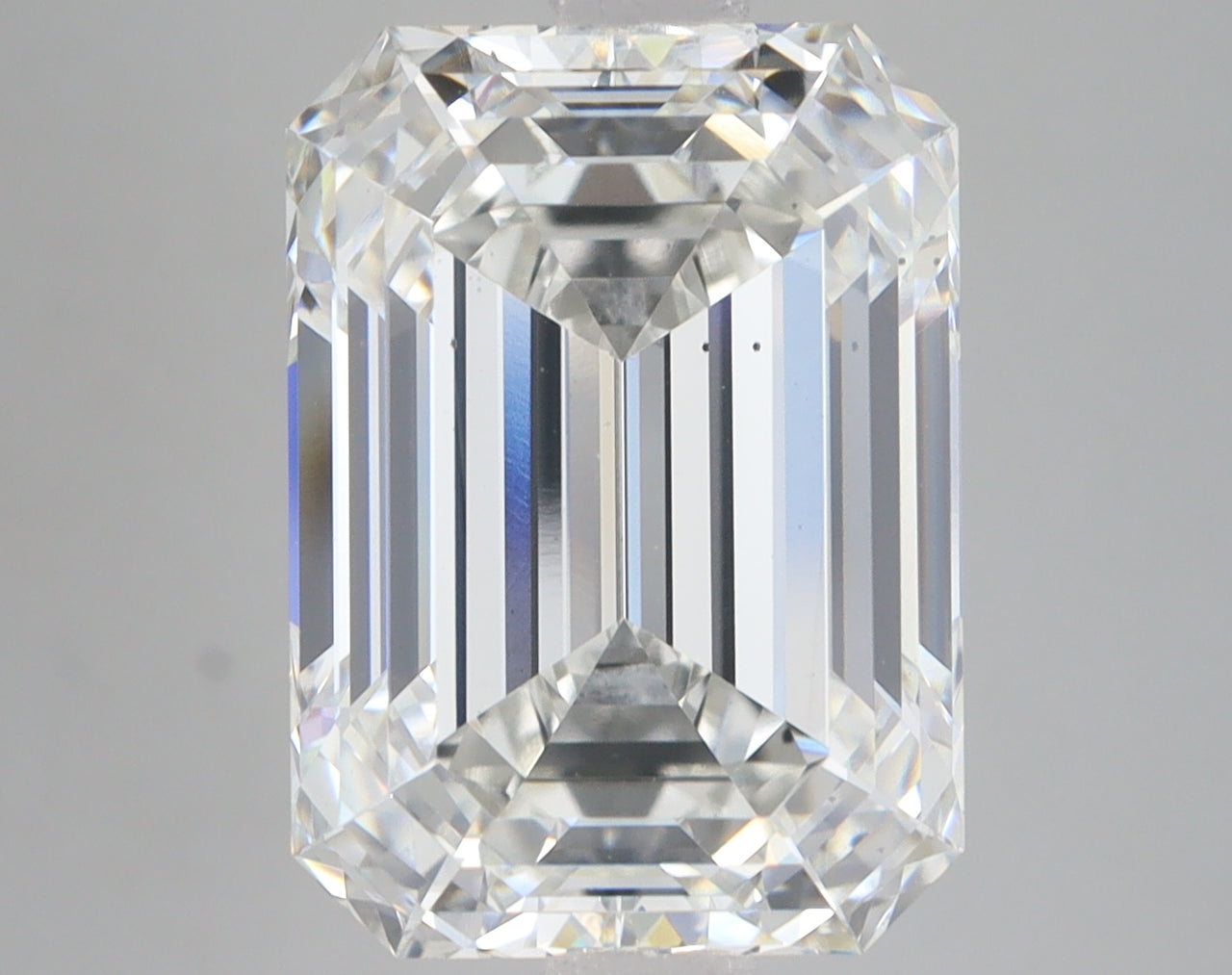 Emerald-cut lab-grown diamond with faceted surfaces reflecting light, displayed against neutral background.