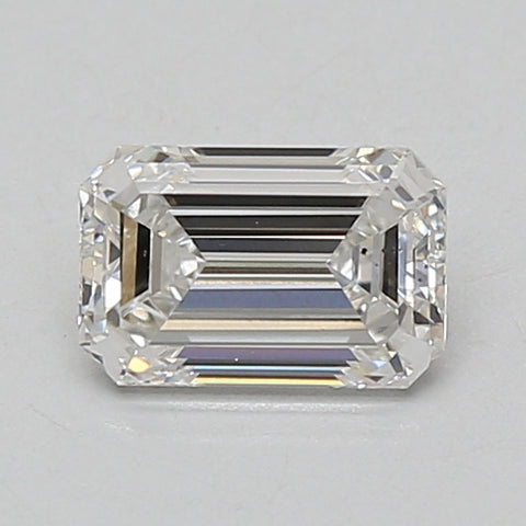 Clear emerald-cut diamond with faceted edges and step-cut pavilion, displayed against neutral background.