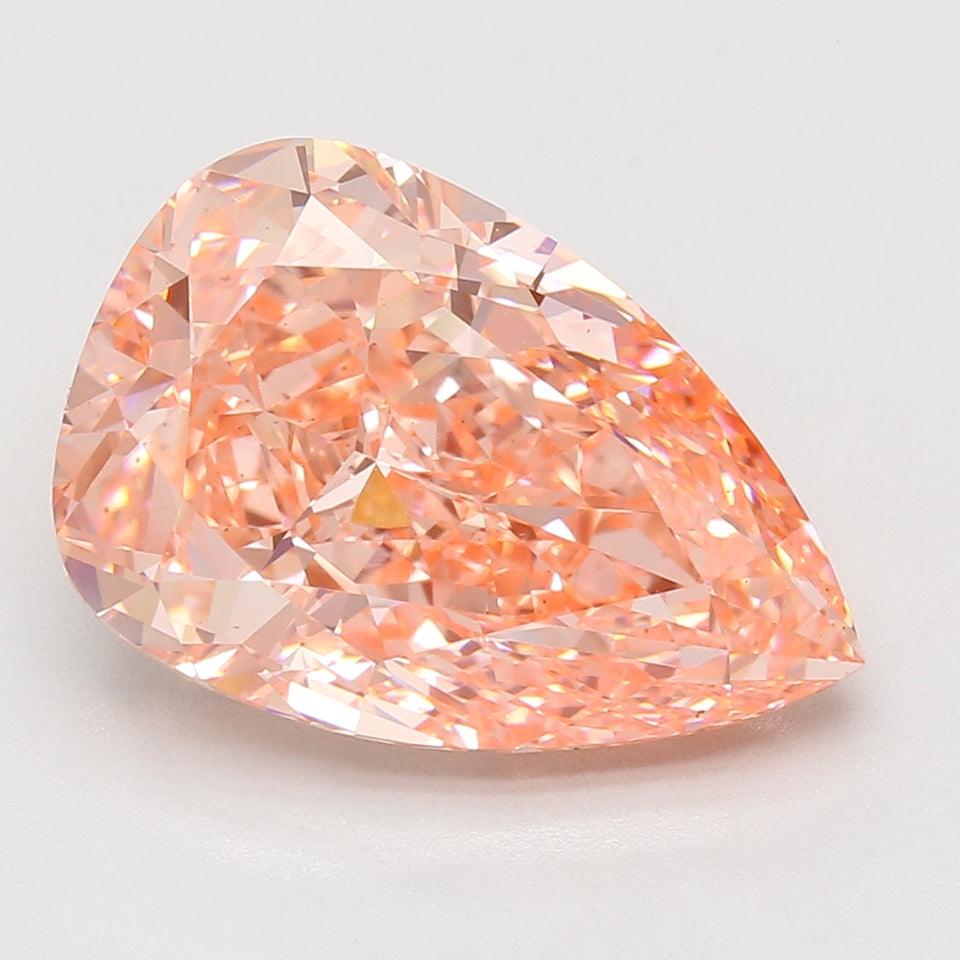 Pear-shaped lab-grown diamond with peachy-pink hue and faceted surface displaying light refraction.
