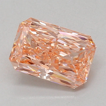 Radiant cut lab grown diamond with peachy-pink hue and faceted surfaces, displayed against neutral background.