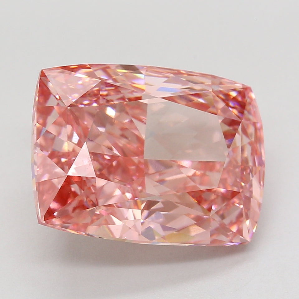 Cushion-cut lab-grown diamond with pink hue and faceted surface reflecting multicolored light.