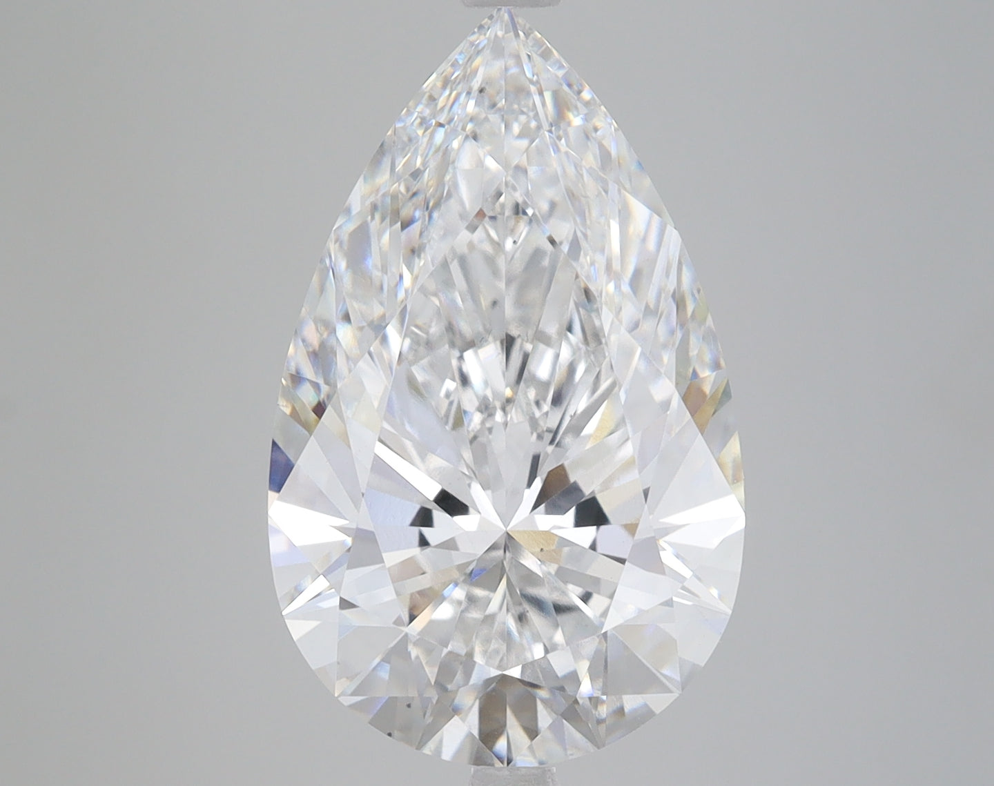 Pear-shaped colorless diamond with faceted surfaces and light reflections on neutral background.