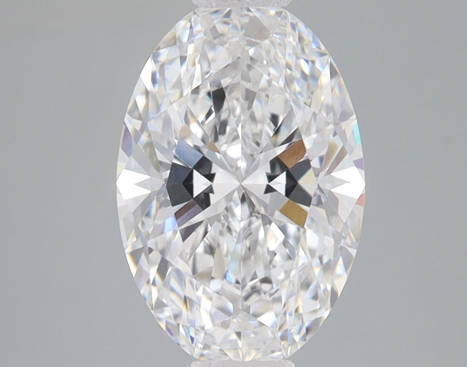 Oval-cut lab-grown diamond with faceted surface displaying light refraction and internal characteristics against neutral back