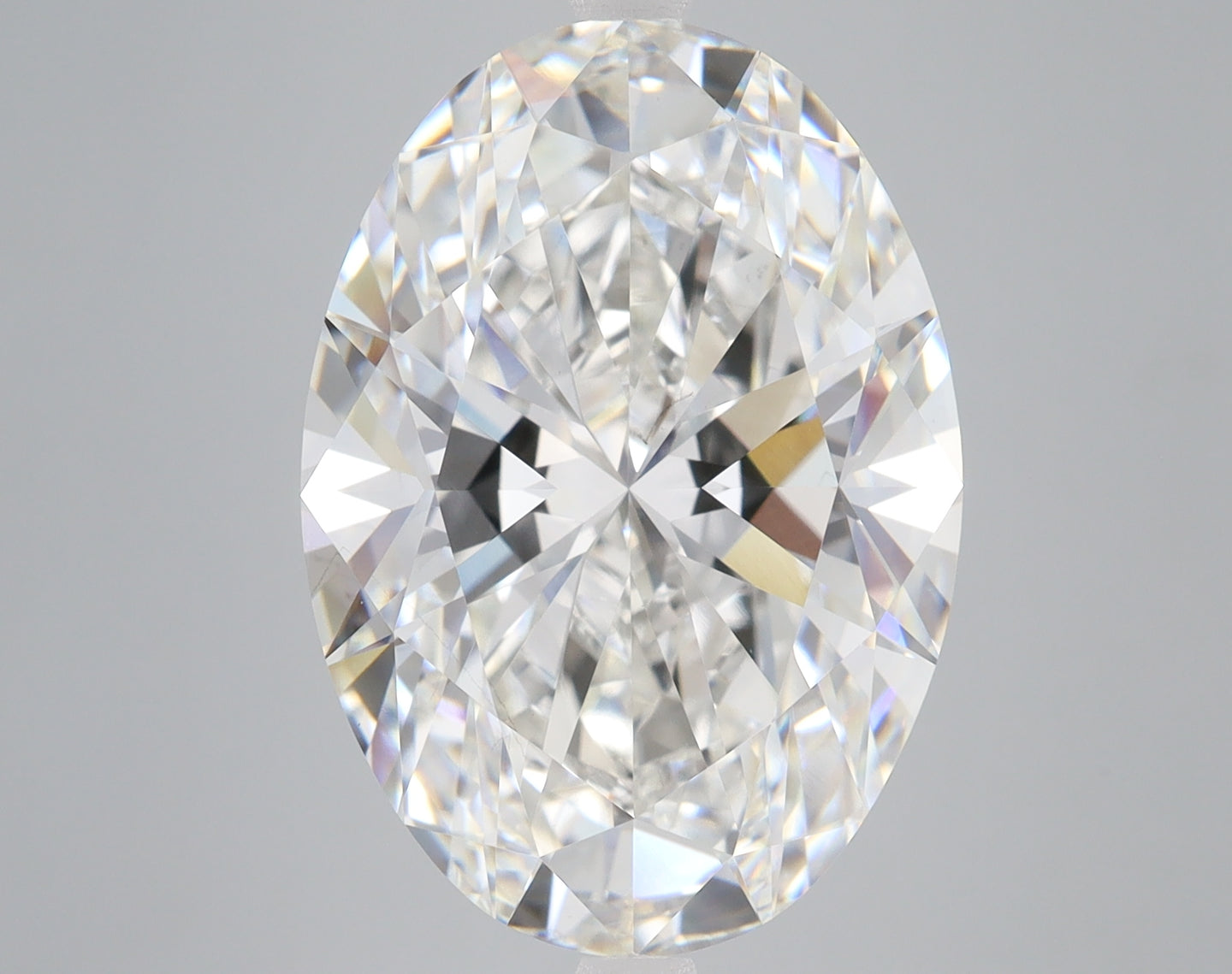 Oval-cut lab-grown diamond with faceted surfaces displaying light refraction on neutral background.
