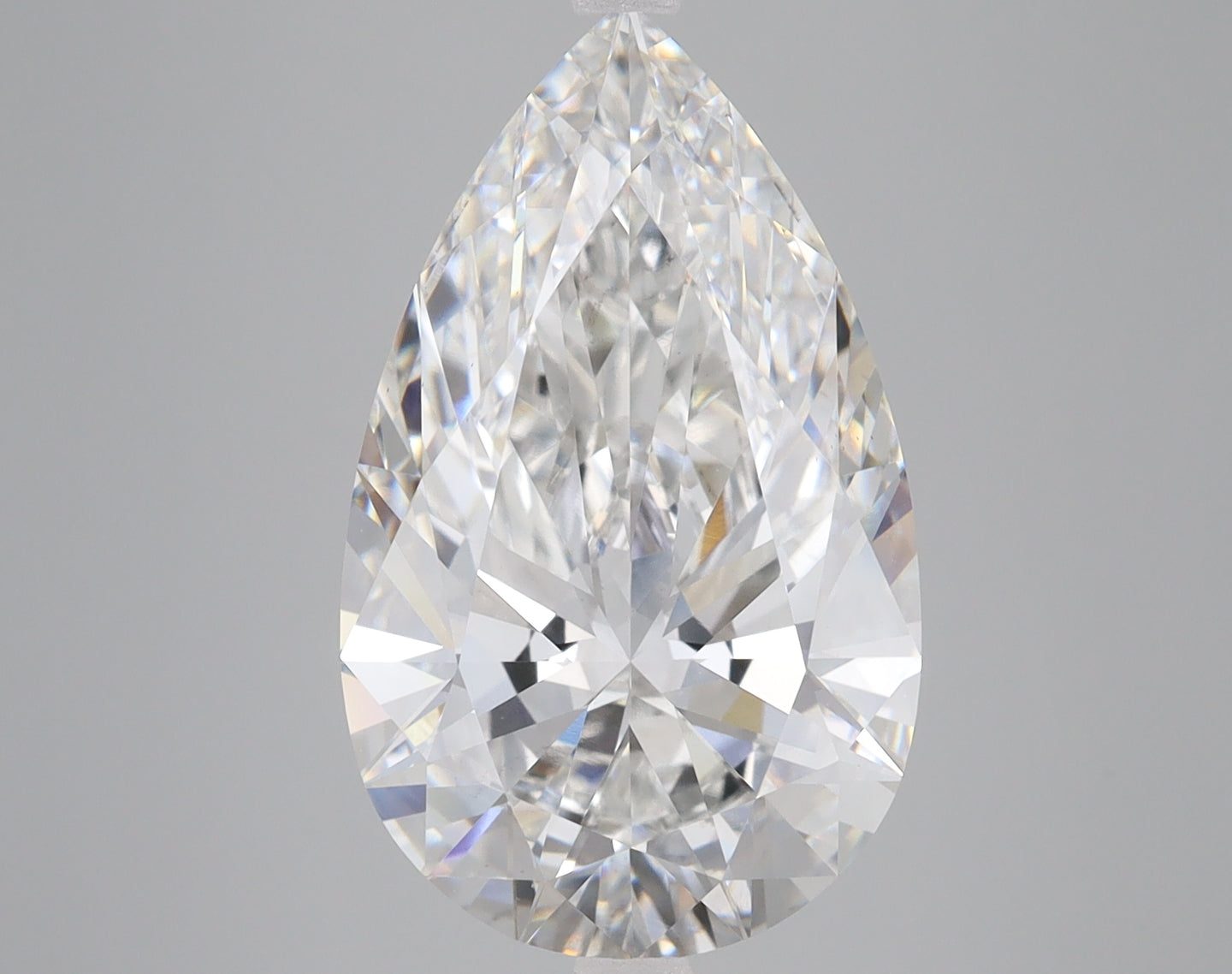 Pear-shaped colorless lab-grown diamond with faceted surfaces reflecting light, displayed against neutral background.