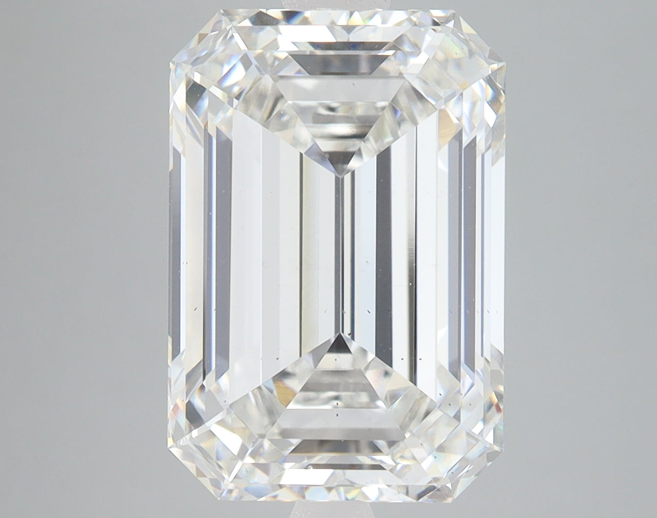 Emerald-cut lab-grown diamond with clear faceting and light reflections on neutral background.