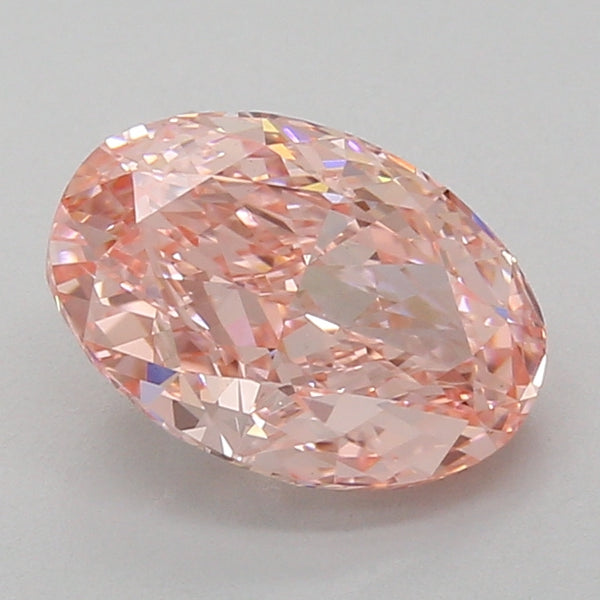Oval-cut lab grown diamond with faceted surface reflecting light, displaying pale pink coloration against a neutral backgroun