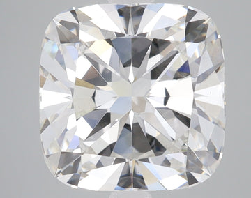 Colorless cushion cut loose diamond with faceted surface reflecting light, displayed against neutral background.