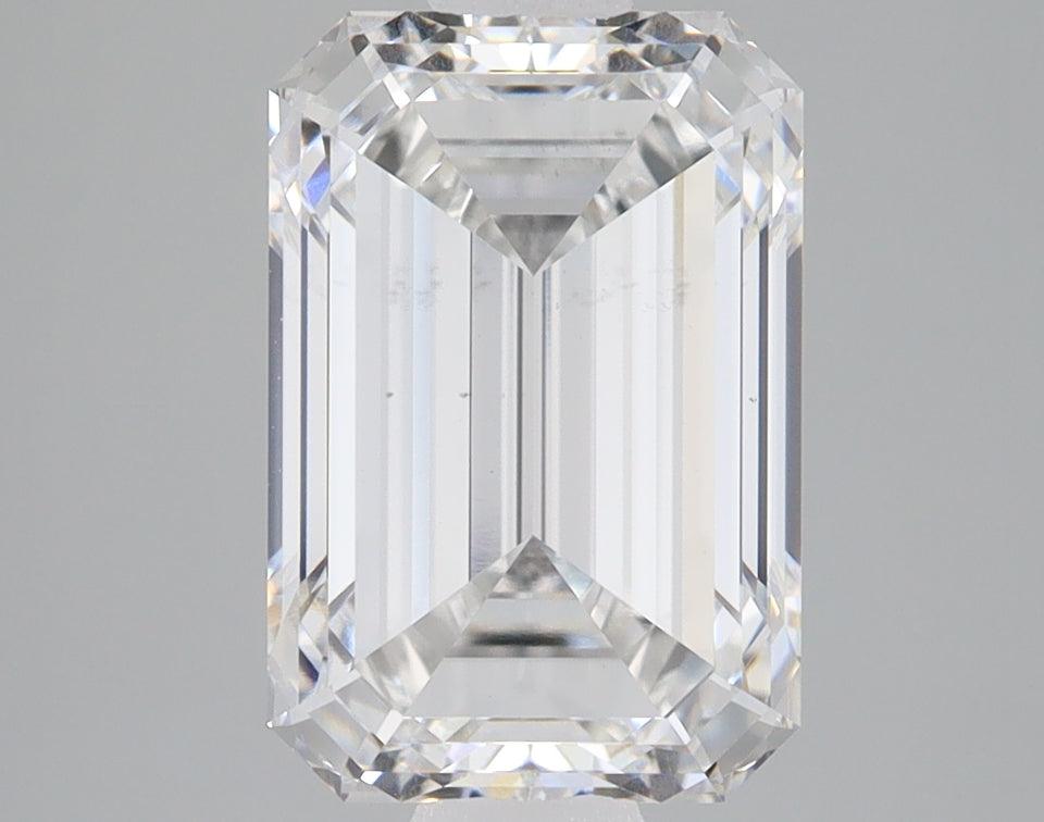 Emerald-cut lab grown diamond loose stone with faceted surfaces and clear transparency, displayed against gray background.
