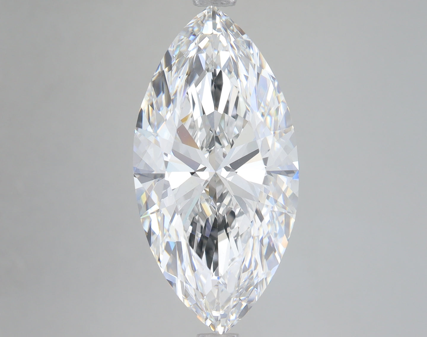 Clear marquise-cut diamond with faceted surfaces reflecting light, displayed against a neutral gray background.