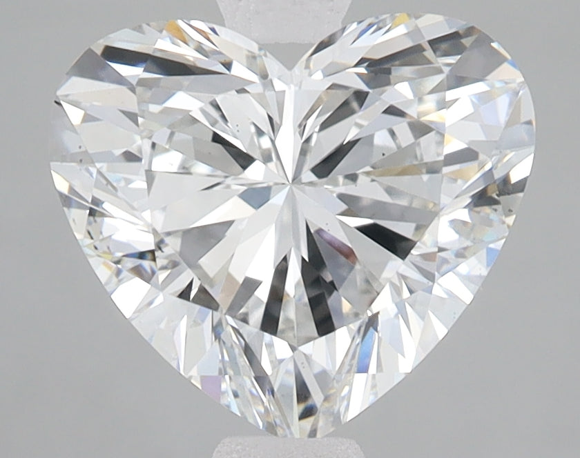 Heart-shaped lab-grown diamond with multiple facets reflecting light, displayed on neutral background.