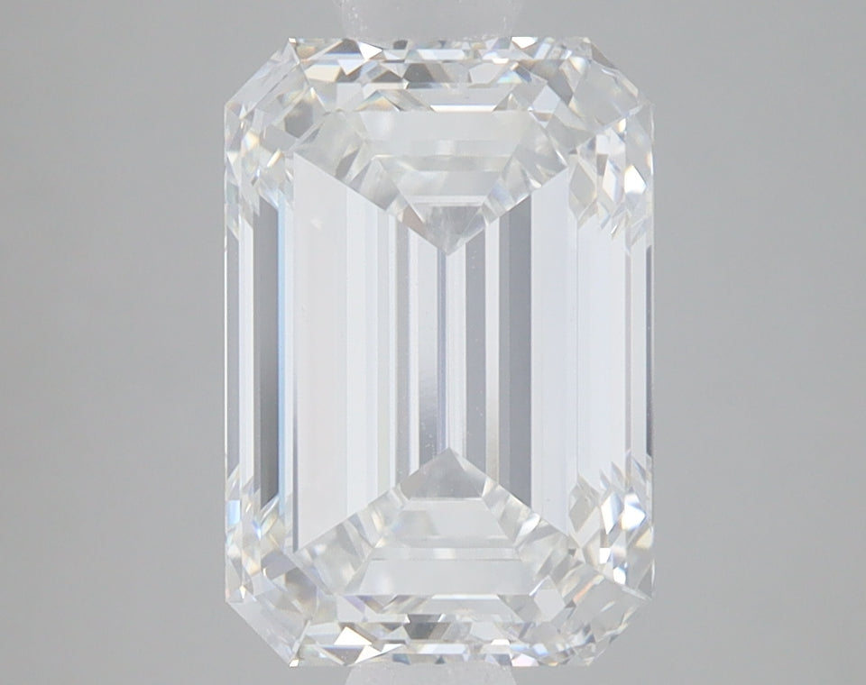 Clear emerald-cut lab-grown diamond with faceted edges and light refraction displayed on neutral background.