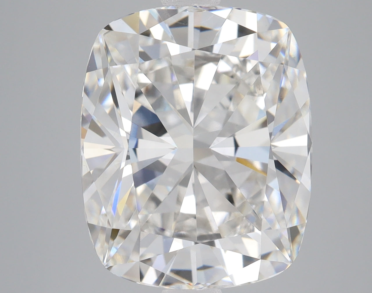 Cushion cut lab-grown diamond with faceted surface displaying light refraction, on neutral gray background.