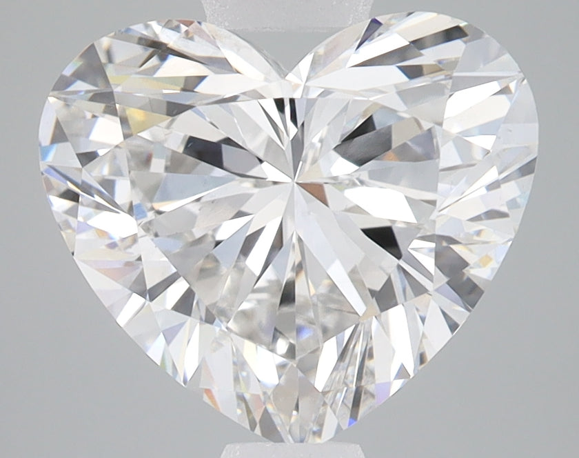 Heart-shaped lab-grown diamond with brilliant faceting and light reflections on gray background.