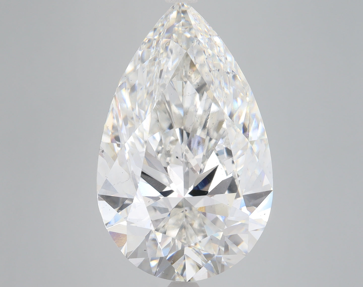 Pear-shaped lab-grown diamond with faceted surfaces and clear coloring, displayed against a neutral gray background.