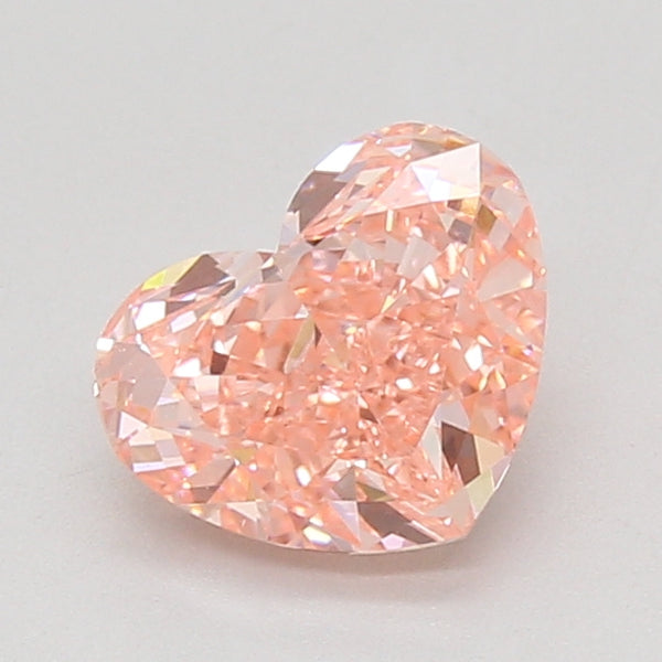 Heart-shaped lab-grown diamond with faceted surface and light pink coloration on neutral background.