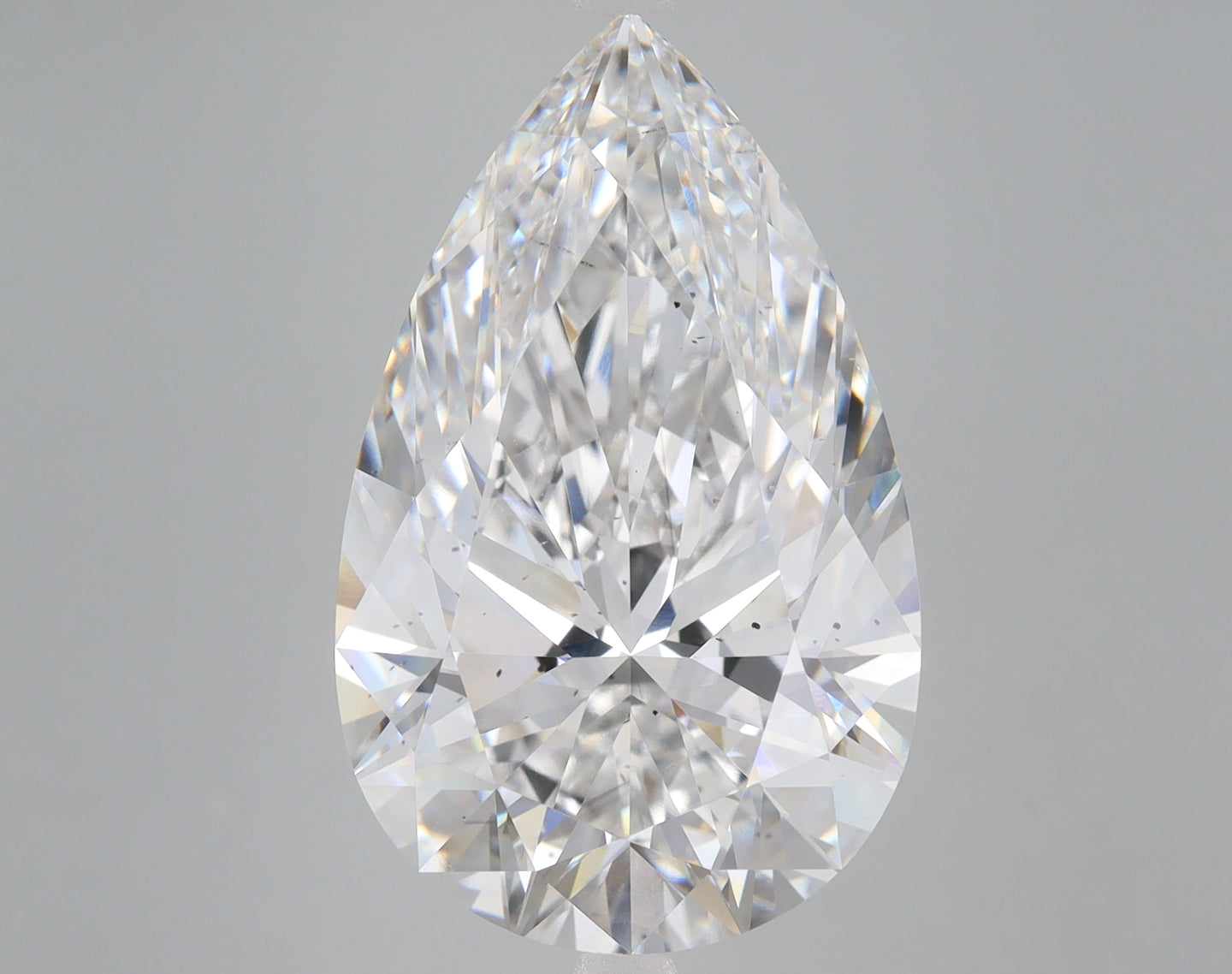 Pear-shaped lab-grown diamond with faceted surfaces reflecting light against a gray background.