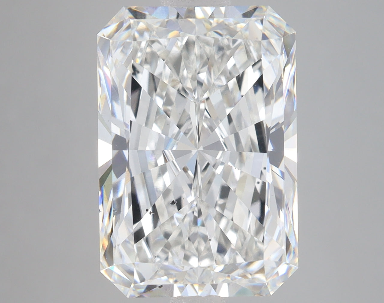Radiant cut loose diamond with faceted surface and bright light reflections on neutral background.