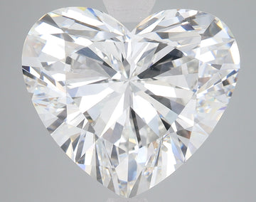 Heart-shaped clear lab-grown diamond with faceted surfaces reflecting light, displayed against gray background.