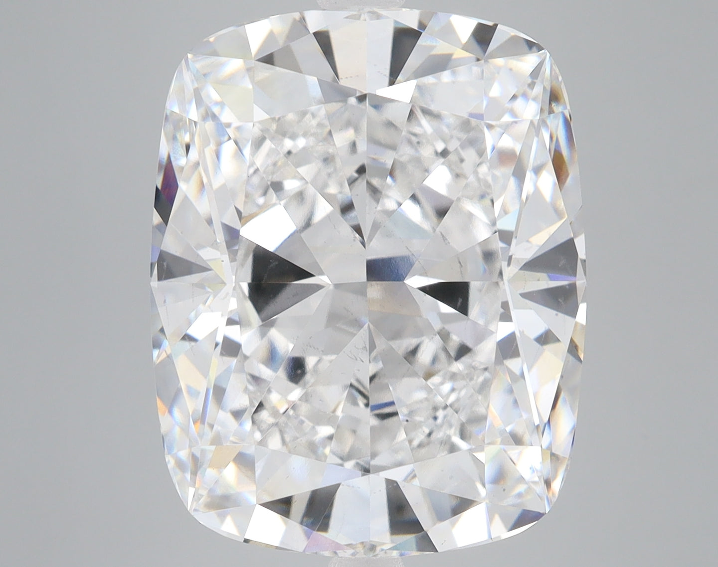 Cushion-cut loose diamond with faceted surfaces reflecting light, displayed against a neutral gray background.
