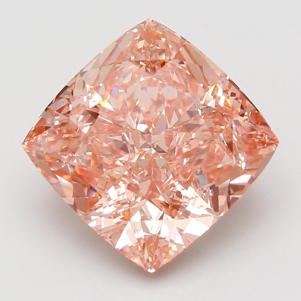 Cushion-cut lab-grown diamond with peachy-pink hue and faceted surface reflecting light, displayed against neutral background