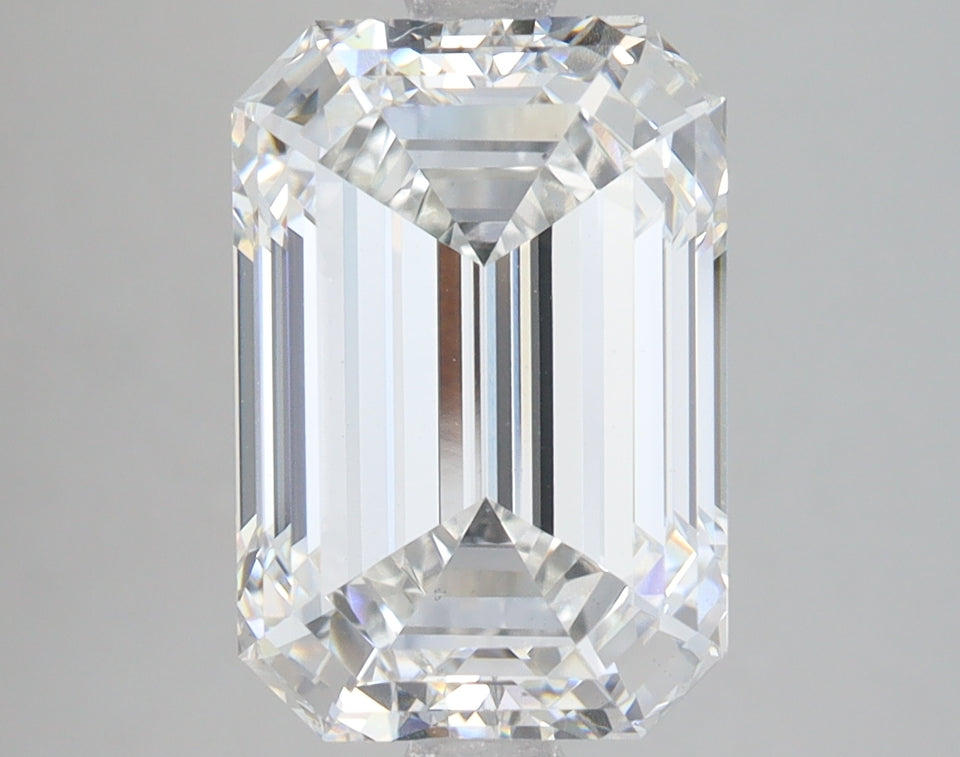 Emerald-cut lab-grown diamond with faceted surfaces and clear transparency, displayed against neutral background.