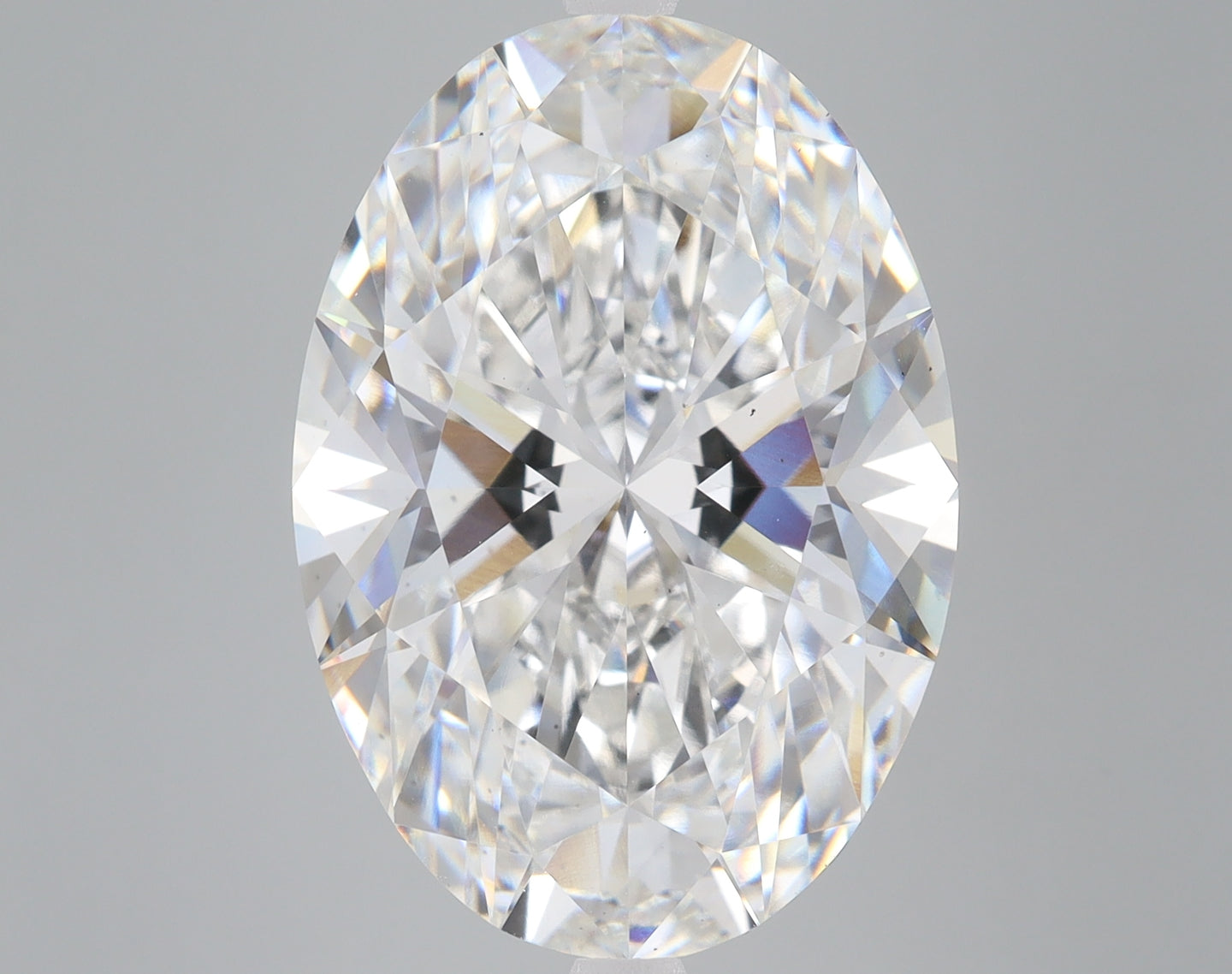 Oval-cut colorless diamond with faceted surfaces and internal light reflections on neutral background.