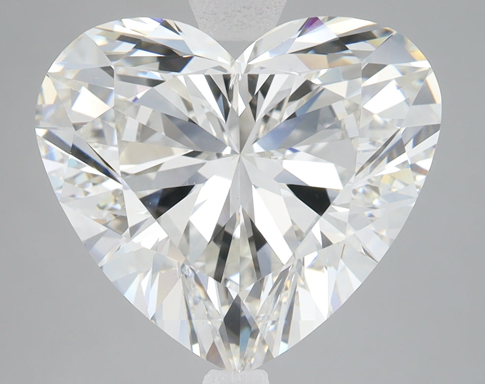 Heart-shaped lab-grown diamond with faceted surface reflecting light, displayed against neutral gray background.