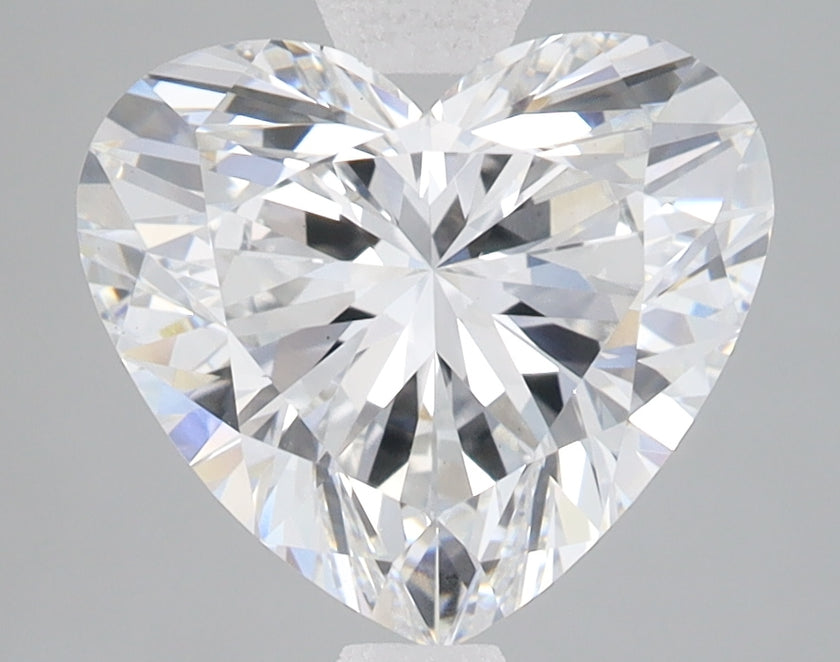 Heart-shaped lab-grown diamond with brilliant faceting and light refraction on gray background.