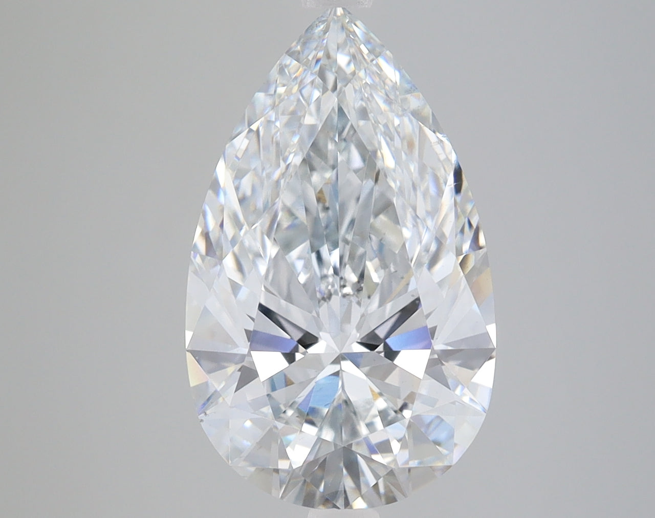 Pear-shaped loose diamond with faceted surfaces and clear crystalline appearance on gray background.