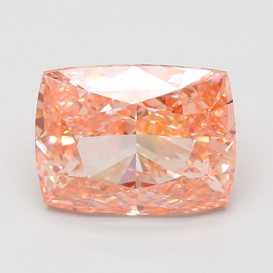 Cushion cut loose diamond stone with peach-pink hue and faceted surface displaying light refraction and sparkle.