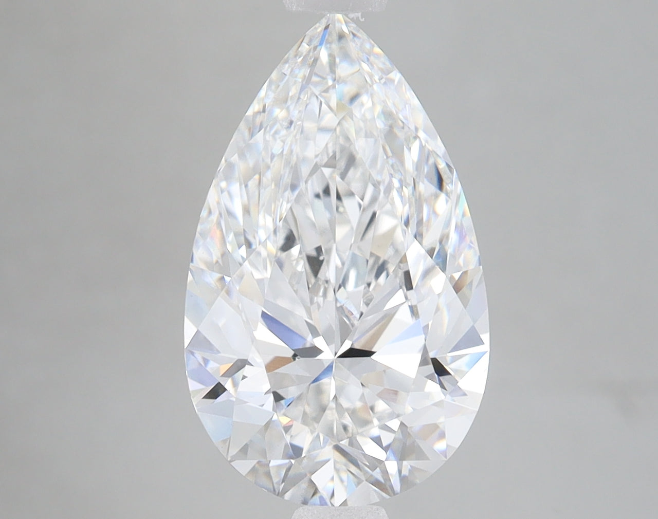 Pear-shaped clear lab-grown diamond with brilliant faceting and light reflections against neutral background.