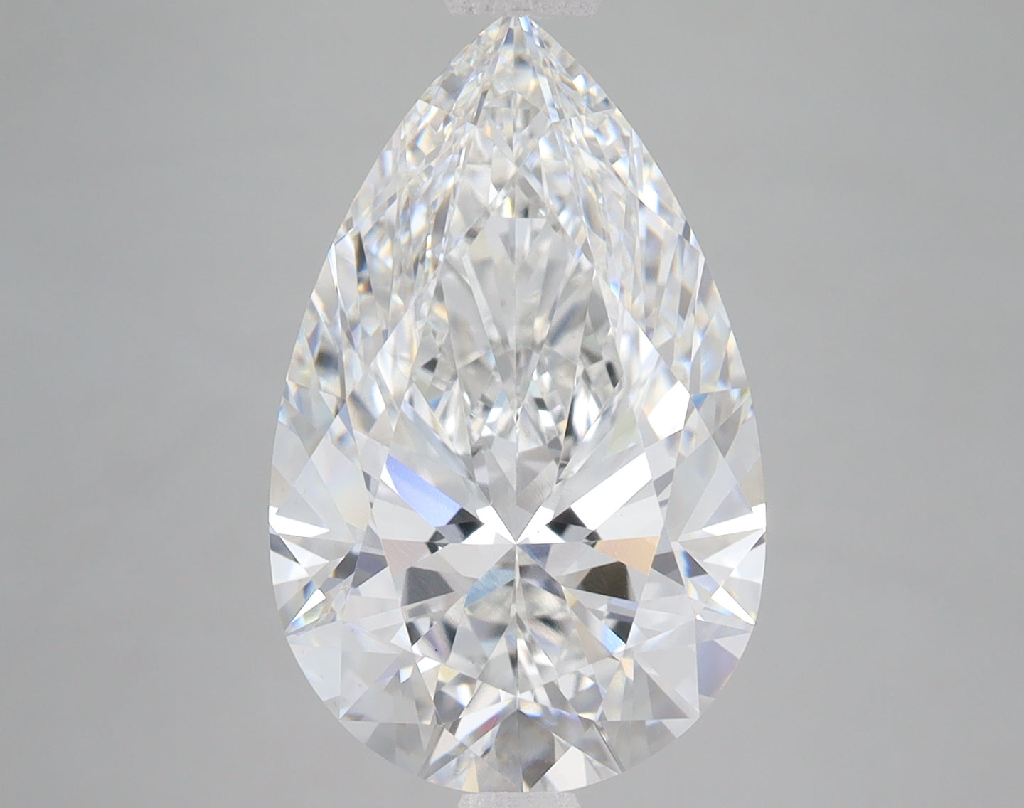 Pear-shaped clear lab-grown diamond with faceted surface and light reflections on gray background.