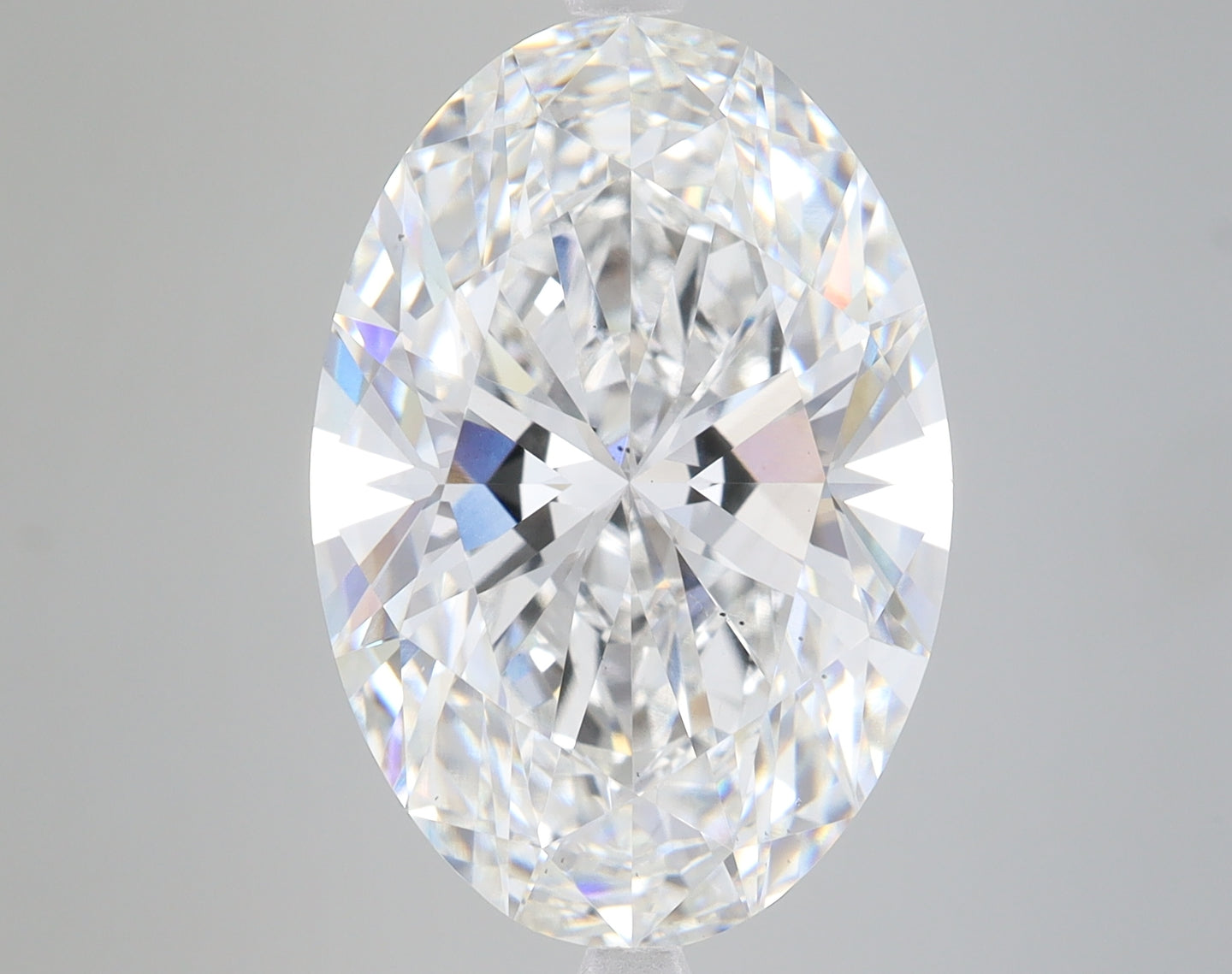 Oval-cut lab-grown diamond with faceted surfaces displaying light refraction and colorless clarity.