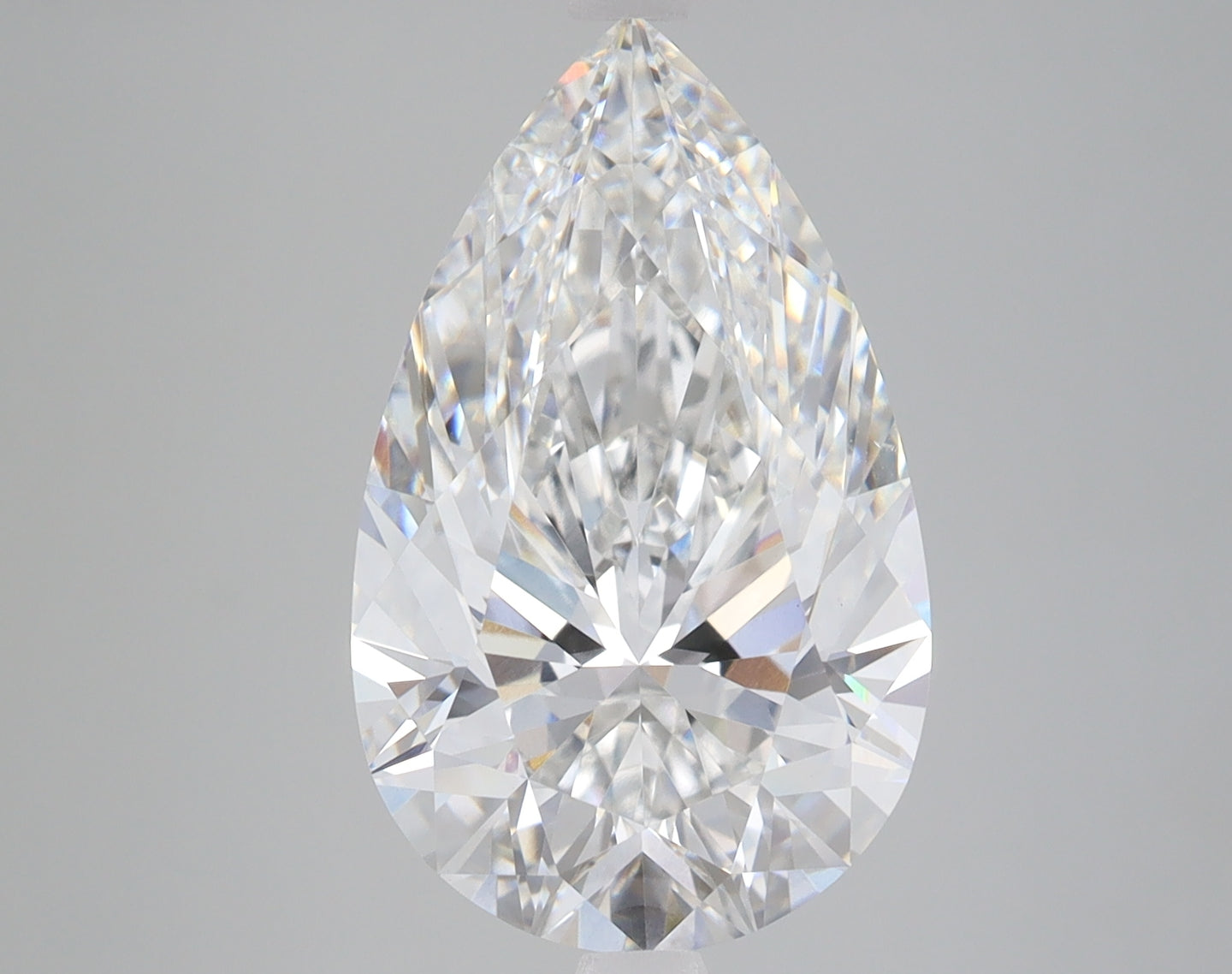 Pear-shaped lab grown diamond with faceted surface and clear coloration against neutral background.