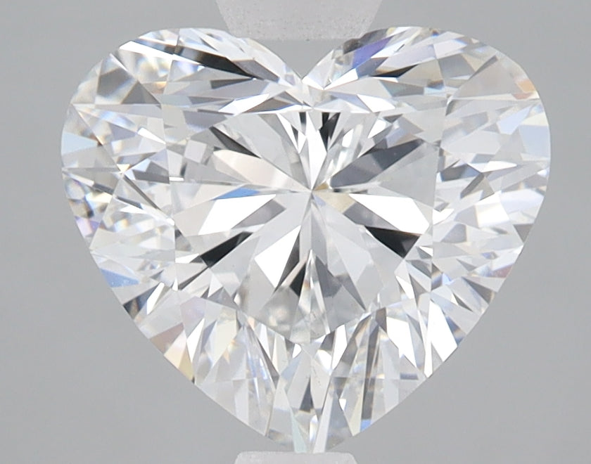 Heart-shaped lab-grown diamond with faceted surface displaying white and blue light reflections.